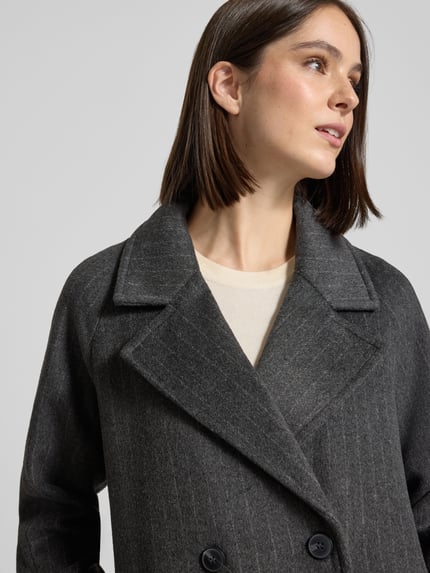 Frauenmodel trägt Mantel mit doppelreihiger Knopfleiste von VERO MODA in Melange-Optik, Nadelstreifen, Nahaufnahme Oberkörper.