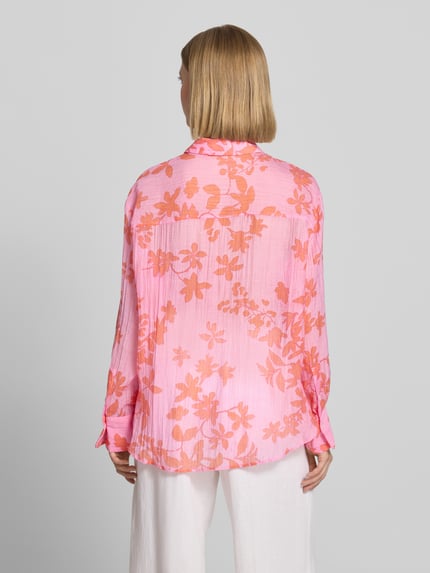 Frauenmodel trägt Regular Fit Hemdbluse aus Lyocell-Mix von Mango in Rosa mit orangefarbenem floralem Allover-Print, semitransparent, Ganzkörperansicht Rückansicht.