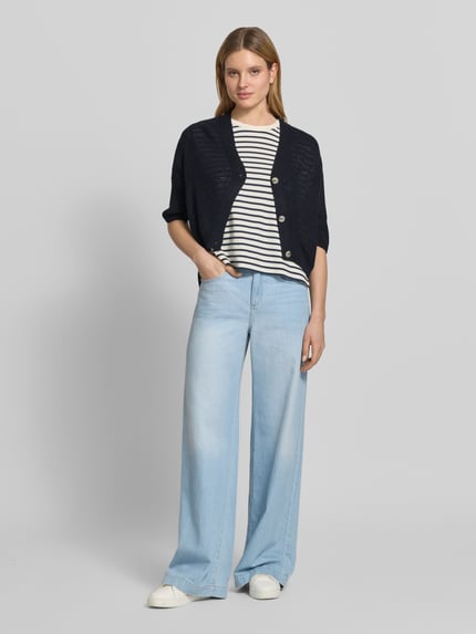 Frauenmodel trägt Cardigan mit V-Ausschnitt und 3/4-Arm von More & More in Dunkelblau, Relaxed-Fit, mit Knopfleiste, Ganzkörperansicht von vorne. Rückenlänge 48 cm, Ärmellänge 24 cm, Größe 36, leichte Stricktextur und deutliche Farbkontraste.