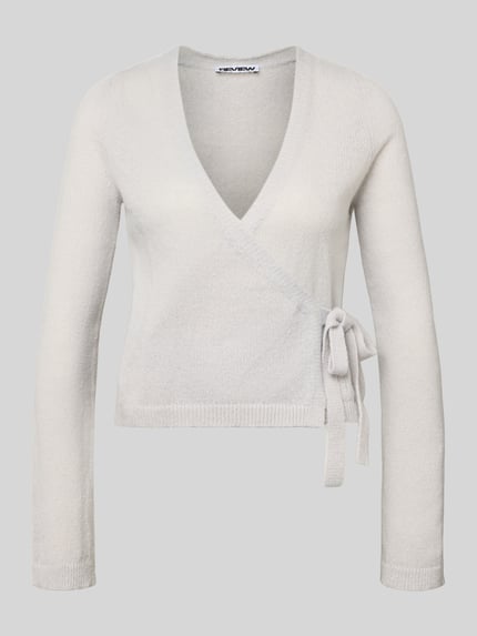 Produktfoto, Strick-Cardigan in Wickeloptik von Review in Hellgrau, Regular-Fit, V-Ausschnitt, lange Ärmel, Verschluss mit Schleife, Rückenlänge 50 cm, Ärmellänge 66 cm bei Größe S, feines Strickmuster, glatte Struktur.