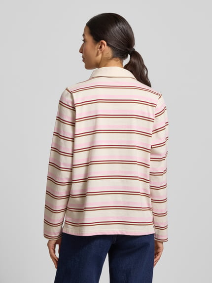Frauenmodel trägt Poloshirt aus reiner Baumwolle von Soyaconcept in Beige mit rosa und roten Streifen, gerader Schnitt, Ganzkörperansicht Rückansicht.