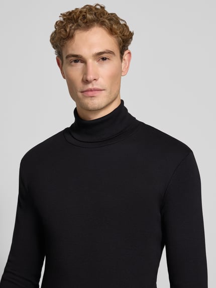 Männermodel trägt Regular Fit Langarmshirt aus reiner Baumwolle von Marc O'Polo in Schwarz, glatte Textur, Nahaufnahme Oberkörper.