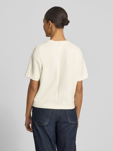 Vrouwenmodel draagt T-Shirt uit modal-mix met ronde hals, model 'Gosa' van OPUS, regular fit, crème, gladde textuur, volledig zicht achteraan.