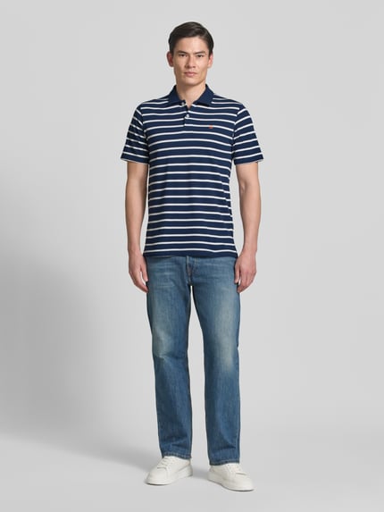 Männermodel trägt Regular Fit Poloshirt mit Logo-Stitching Modell 'Adam' von Jack & Jones Premium, Reine Baumwolle, Kurzärmelig, Polo-Kragen, Ganzkörperansicht von vorne.