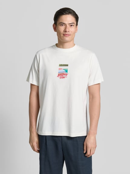 Männermodel trägt Regular Fit T-Shirt aus reiner Baumwolle Modell 'ASPEN' von SELECTED HOMME in Optik: Unifarben mit Motiv-Print, Rundhals, Kurzarm, Materialverarbeitung: Jersey, Ganzkörperansicht von vorne.