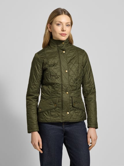 Modelka nosi Regular Fit Steppjacke mit Stehkragen Modell 'FLYWEIGHT' od Barbour, efekt: jednolity kolor, krój regular fit, stójka, zatrzaski, długi rękaw, kieszenie z patką, wykończenie materiału: pikowanie; kolor oliwkowy, złote detale, tekstura pikowana. Ganzkörperansicht von vorne.