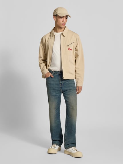 Männermodel trägt Regular Fit Blouson aus reiner Baumwolle von Kenzo in Beige mit Label-Stitching und Reißverschlusstaschen, Ganzkörperansicht von vorne. Rückenlänge 66 cm, Schulterbreite 50 cm, Ärmellänge 66 cm.
