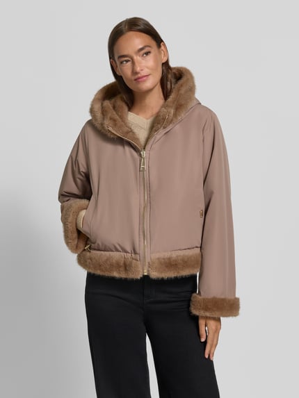 Frauenmodel trägt Jacke mit Kapuze und Kimonoärmeln von Liu Jo Sport in Beige mit Reißverschluss und Kunstfell, Nahaufnahme Oberkörper. Rückenlänge 54 cm, Schulterbreite 38 cm, Brustweite 56 cm, Ärmellänge 92 cm.