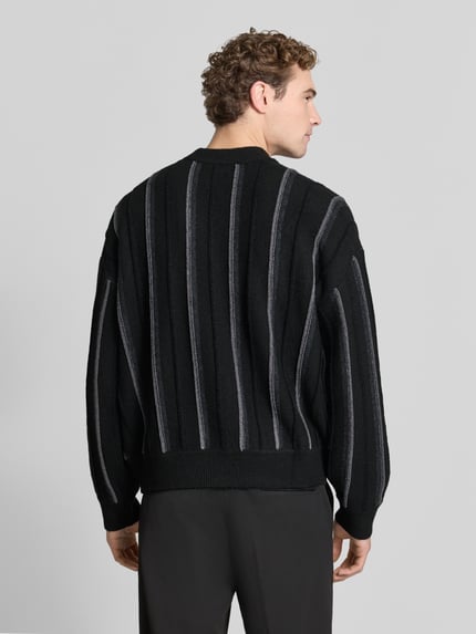 Männermodel trägt Pullover mit Strukturstrick-Details von COLUCCI, gestreiftes Strickdesign, Rundhals, Regular Fit, Ganzkörperansicht Rückansicht.