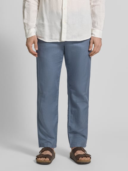 Mannelijk model draagt Regular Fit Leinenhose aus Baumwoll-Leinen-Mix Modell 'MILES' van SELECTED HOMME in uni blauw, mid waist, straight from knee, 5-pocket, knoop- en ritssluiting, katoen-linnenmix, frontale close-up van benen.