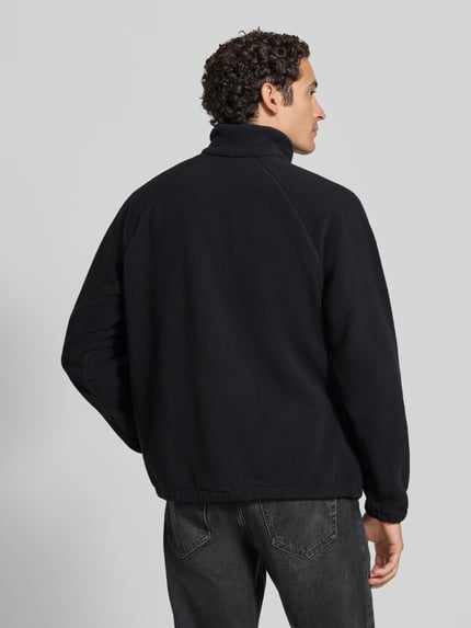 Männermodel trägt Fleecepullover mit Logo-Patch Modell 'Timber Crest™ MTR' von Columbia, Schwarztöne, Troyer-Kragen, Rückenansicht, Ganzkörperansicht Rückansicht. Relaxed Fit, Raglanärmel, Fleece-Struktur.