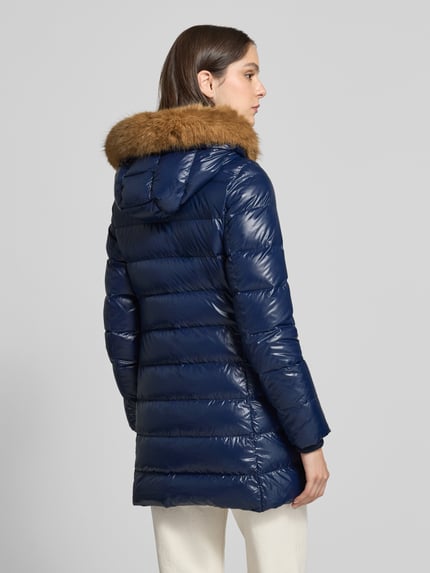 Frauenmodel trägt Puffer Coat mit abnehmbarer Fellkapuze von Tommy Hilfiger in glänzendem Dunkelblau, Longline, Rückenansicht.