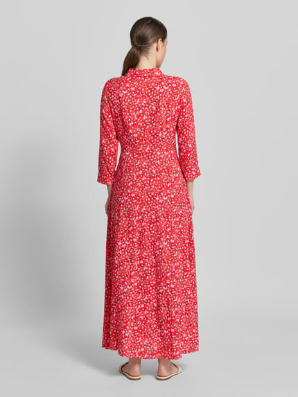 Vrouwenmodel draagt overhemdjurk van zuiver viscose in A-lijn als maxi-jurk, all-over look in rood met knoopsluiting, model 'SAVANNA' van YAS, ruglengte maat S 140 cm, borstwijdte 47 cm, mouwlengte 49 cm, geheel in beeld, rugaanzicht.