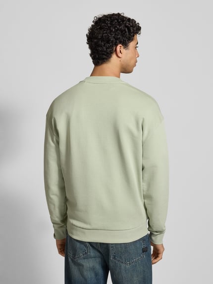 Männermodel trägt Regular Fit Sweatshirt aus reiner Baumwolle Modell 'NIEROFIX_CREW' von Hugo Blue, Optik: Unifarben, Ganzkörperansicht Rückansicht.