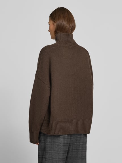 Frauenmodel trägt Wollpullover mit Rollkragen von Style Icon Collection in Braun, lockerer Schnitt, gerippte Abschlüsse, Rückenansicht, ganzkörper.