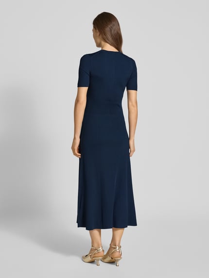 Frauenmodel trägt Eng anliegendes Freizeitkleid aus Viskose-Mix von Tommy Hilfiger, Optik: Unifarben, Passform: eng anliegend, Midi-Länge, Rundhals, Logo-Detail, Zierknöpfe, Knopfleiste, Kurzarm, Ganzkörperansicht Rückansicht.