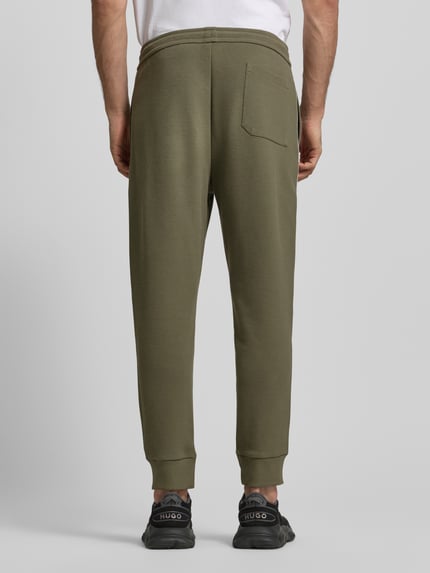 Männermodel trägt Regular Fit Sweatpants aus Baumwoll-Mix Modell 'JOIN HADIKO' von BOSS Green, Optik: Unifarben, Piqué, Ganzkörperansicht Rückansicht.