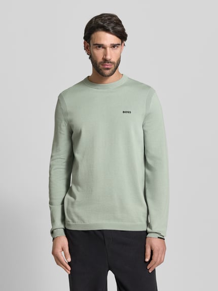 Mannenmodel draagt Regular Fit Strickpullover aus reiner Baumwolle Modell 'EVER-X' van BOSS Green in effen lichtgroen, crew neck, lange mouw, fijne breistructuur, label detail, detailopname bovenlichaam, frontaal.
