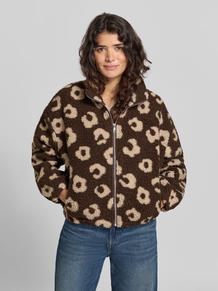 Vrouwenmodel draagt Jacke met Stehkragen Modell 'Lo44ra' van ZABAIONE, bruine en beige tinten, loose fit, ritssluiting, zijsteekzakken, elastische boorden, ruglengte maat S 55 cm, mouwlengte maat S 59 cm, getextureerde teddylook, bovenlichaam close-up vooraanzicht.