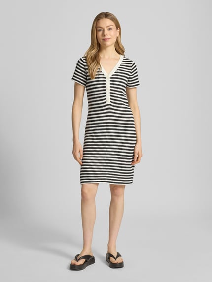 Frauenmodel trägt Knielanges Strickkleid mit V-Ausschnitt Modell 'LORIANNA' von ICHI, Baumwoll-Mix, schwarz-weiß gestreift, körpernah, Ganzkörperansicht von vorne.