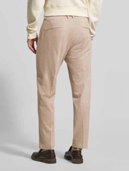 Männermodel trägt Regular Fit Hose aus Viskose-Mix Modell 'CIJUNO-O' von CINQUE in Beige mit Bundfalten und Knopfverschluss, Ganzkörperansicht Rückansicht.