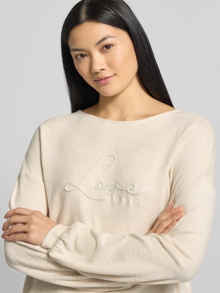 Frauenmodel trägt Regular Fit Sweatshirt aus Viskose-Mix von Tom Tailor in Melange-Optik mit Statement-Stitching, Rundhals, Langarm, Nahaufnahme Oberkörper.