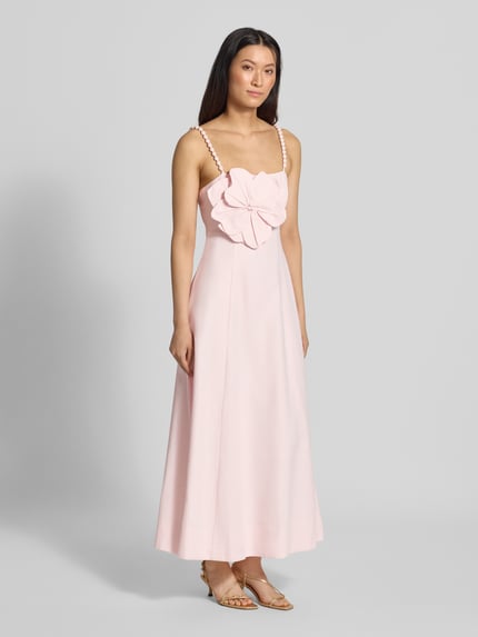 Frauenmodel trägt Abendkleid aus Leinen-Viskose-Mix Modell 'Nicolette' von Forever New in zartem Rosa mit floraler Zier-Applikation, Karree-Ausschnitt, Spaghettiträgern, Midilänge und dezenter Textur, Ganzkörperansicht von vorne.