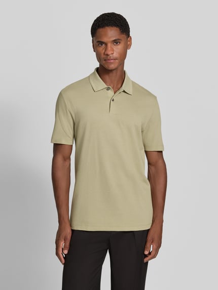 Männermodel trägt Regular Fit Poloshirt aus Baumwoll-Mix Modell 'PARLAY 240' von BOSS in Unifarbe mit Polokragen, Kurzarm, Ganzkörperansicht von vorne.