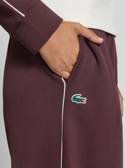 Kobiece model nosi Regular Fit Sweathose aus Baumwoll-Mix od Lacoste, kolor bordowy, gładka tekstura, sport, zbliżenie na biodro.
