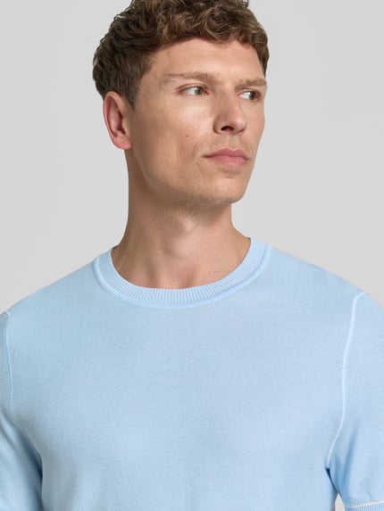 Mannermodel draagt Regular Fit T-shirt uit tricotlook model 'H-NALON' van BOSS in lichtblauw, katoenmix, nahaufnahme bovenlichaam.