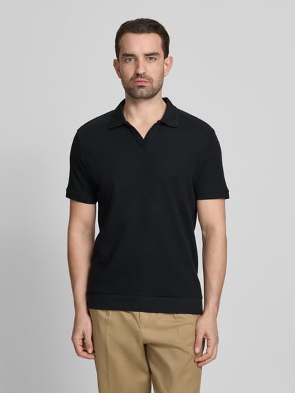 Męski model nosi Comfort Fit Poloshirt mit V-Ausschnitt von Lindbergh z bawełny, fakturowany wzór, detal z logo, długość tyłu 68 cm, Ganzkörperansicht von vorne