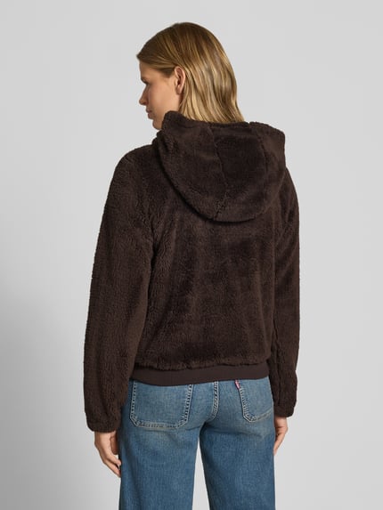 Frauenmodel trägt Regular Fit Teddyjacke mit Kapuze Modell 'NEWANNA' von ONLY in Braun, strukturierte, flauschige Oberfläche, Damen Sweatjacke, Ganzkörperansicht Rückansicht.