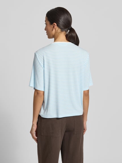Kobiece modelka nosi damski t-shirt Regular Fit T-Shirt aus Modal-Mix model 'Jana' od MSCH Copenhagen, mieszanka modalu, okrągły dekolt, rękaw o dł. 1/2, długość tyłu w rozmiarze S/M 53 cm, drobne niebiesko-białe paski, tekstura gładka, widok całej sylwetki z tyłu.