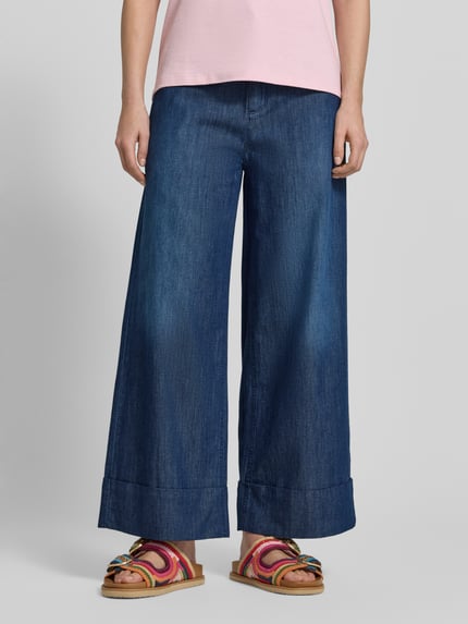 Frauenmodel trägt Wide Leg Jeans in verkürzter Passform Modell 'VELINA' von SEDUCTIVE aus reiner Baumwolle im Used-Look, Nahaufnahme Unterkörper.