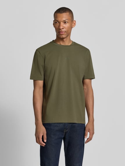 Männermodel trägt Regular Fit T-Shirt aus Baumwoll-Mix Modell 'TCHUP' von BOSS Orange in Olivgrün, glatte Oberfläche, Ganzkörperansicht von vorne. Herren T-Shirt