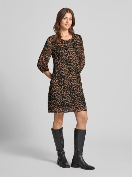 Kobiece modelka trägt Knielanges Kleid mit Schlüssellochausschnitt von ZABAIONE w kolorze czarnym i brązowym z efektem fałdowania, krój relaxed fit, długość do kolan, rękaw o dł. 1/2, Długość tyłu w rozmiarze S: 93 cm, Szerokość w rozmiarze S: 47 cm, Długość rękawów w rozmiarze S: 44 cm, tekstura przypominająca zwierzęcy wzór, Ganzkörperansicht von vorne.