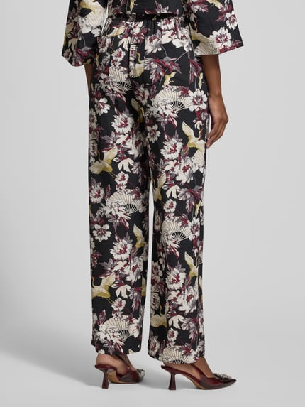 Vrouwenmodel draagt Stoffhose aus Viskose-Mix Modell 'Orelia' van GUIDO MARIA KRETSCHMER WOMAN, wijde pijpen, allover bloemenpatroon, zakken, achteraanzicht volledige lichaamsopname.