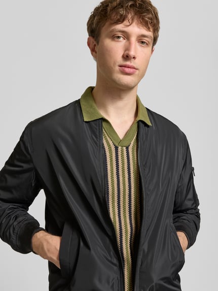 Männermodel trägt Regular Fit Poloshirt in Strick-Optik Modell 'Carly' von Blend in Grün gestreift, Reine Baumwolle, Nahaufnahme Oberkörper.