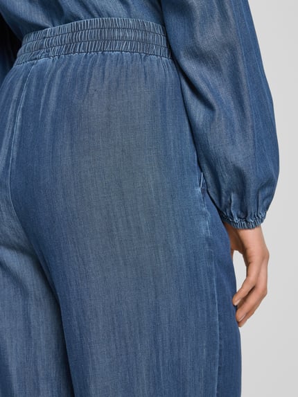 Frauenmodel trägt Loose Fit Jeans mit Viskose-Anteil Modell 'Wilke' von FREE/QUENT, blauer Denim, elastischer Bund, Detailaufnahme Rückenansicht.
