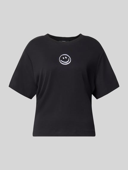 Produktfoto, schwarzes Boxy Fit T-Shirt aus reiner Baumwolle Modell 'SARA' von VERO MODA mit weißem Smiley-Print auf der Brust. Damen T-Shirt.