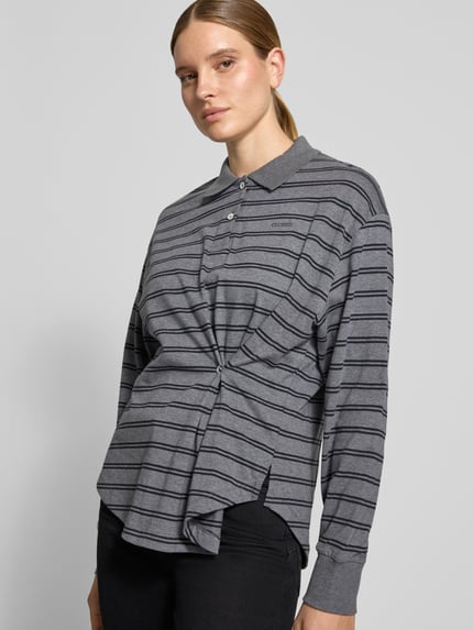 Frauenmodel trägt Relaxed Fit Poloshirt aus reiner Baumwolle von Closed, grau gestreift mit Raffungen, Logo-Print, Langarm, Nahaufnahme Oberkörper.