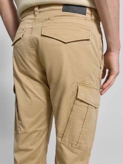 Männermodel trägt Regular Fit Cargohose aus Baumwoll-Mix von s.Oliver RED LABEL, Optik: Unifarben, Detailaufnahme Rückansicht.