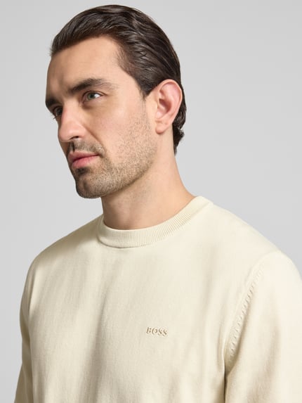 Männermodel trägt Regular Fit Strickpullover aus reiner Baumwolle Modell 'UPCAS' von BOSS, Optik: unifarben, Nahaufnahme Oberkörper.