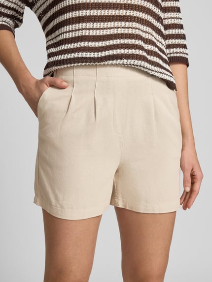 Frauenmodel trägt Relaxed Fit Bermudas aus Viskose-Leinen-Mix Modell 'JESMILO' von Vero Moda in Optik: Unifarben, Flammgarn, seitliche Eingrifftaschen, Nahaufnahme Oberkörper.