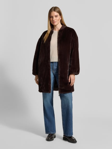Frauenmodel trägt Regular Fit Mantel aus Kunstfell Modell 'Wender' von Beaumont Amsterdam in Dunkelbraun, Zweiwege-Reißverschluss, Stehkragen, Ganzkörperansicht von vorne, Rückenlänge 92 cm, Schulterbreite 54 cm, Brustweite 46 cm, Ärmellänge 62 cm.