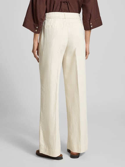 Frauenmodel trägt Hose aus Baumwoll-Leinen-Mix Modell 'Meeri costal' von OPUS in Creme mit weitem Bein und Bindegürtel, Ganzkörperansicht Rückansicht.