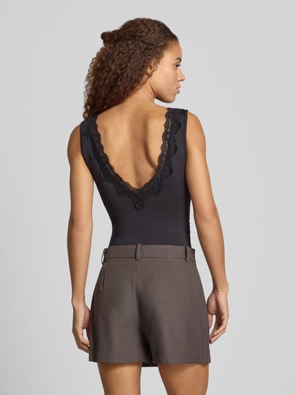 Frauenmodel trägt Wäschebody mit Spitzeneinsatz am V-Ausschnitt von ONLY, unifarben, breite Träger, Jersey-Material, Ganzkörperansicht Rückansicht.