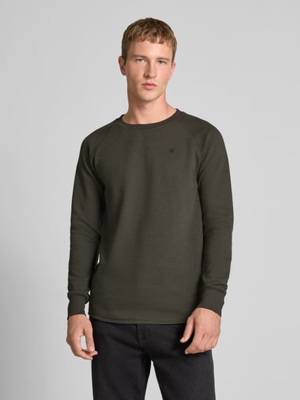 Männermodel trägt Longsleeve mit Strukturmuster und Logo von G-Star Raw, regular fit, katoenmix, ronde hals. Ganzkörperansicht von vorne.