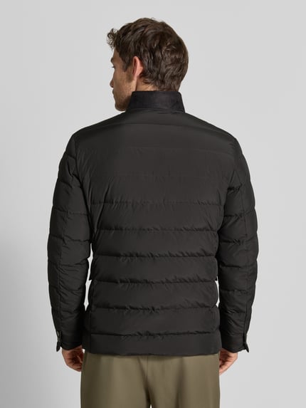 Männermodel trägt schwarze Regular Fit Jacke in Stepp-Optik Modell 'Joen' von Tiger of Sweden mit Stehkragen, Ganzkörperansicht Rückansicht.