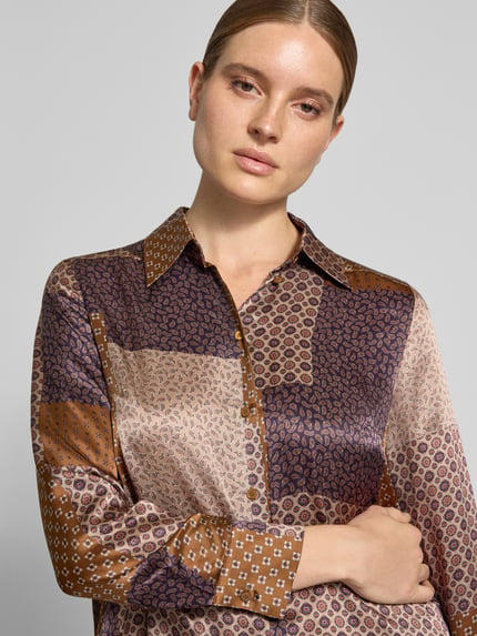 Vrouwenmodel draagt Regular fit blouse uit zuiver zijde in all-over look van Luisa Cerano met overhemdkraag en knoopsluiting, patchworkpatroon in bruin- en paarstinten, context: dames blouse, ruglengte maat 36: 64 cm, mouwlengte maat 36: 63 cm, detailopname bovenlichaam.